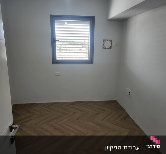 חדר ריק עם רצפת פרקט ודלת פתוחה